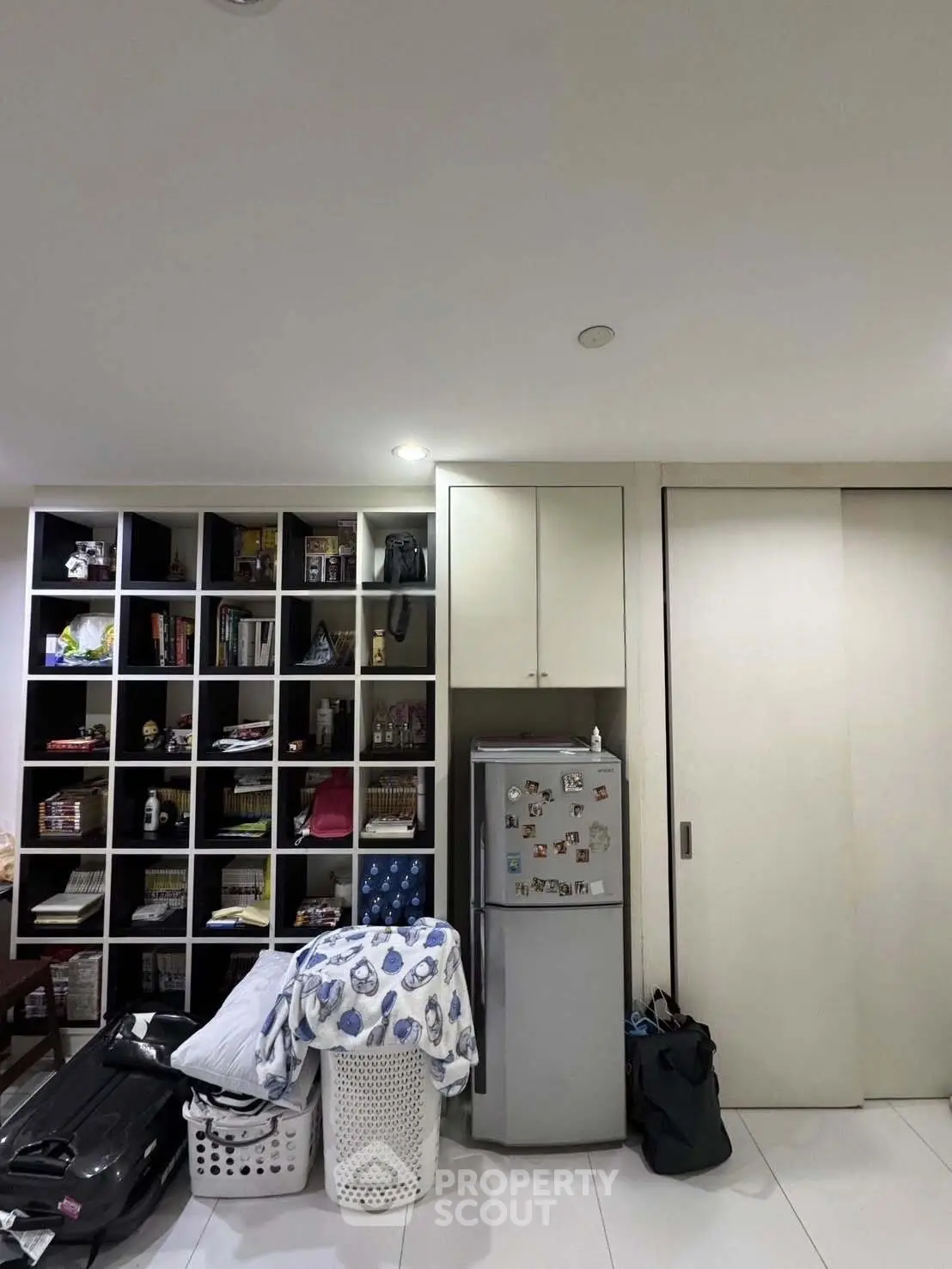 Compact storage area with shelves and mini fridge in modern apartment