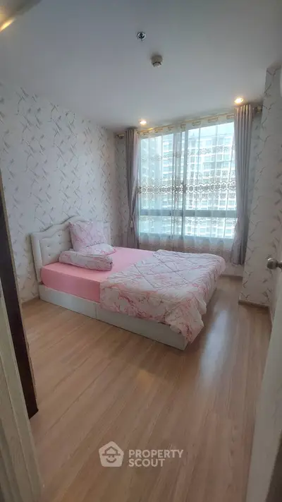 Cozy bedroom with modern decor and large window in urban apartment