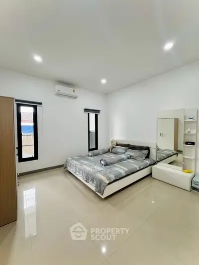 Spacious modern bedroom with sleek design and ample natural light