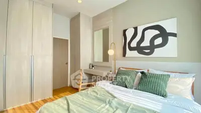 Modern bedroom with stylish decor and ample natural light, featuring a cozy bed and built-in wardrobe.