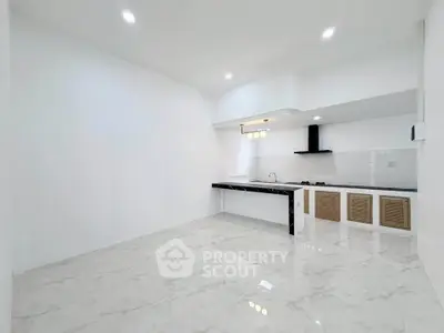 Modern kitchen with sleek design and marble flooring in a spacious open layout.