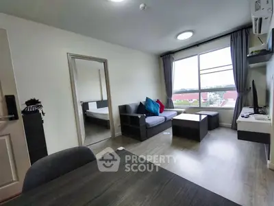 Modern living room with natural light and stylish furniture in a cozy apartment setting.