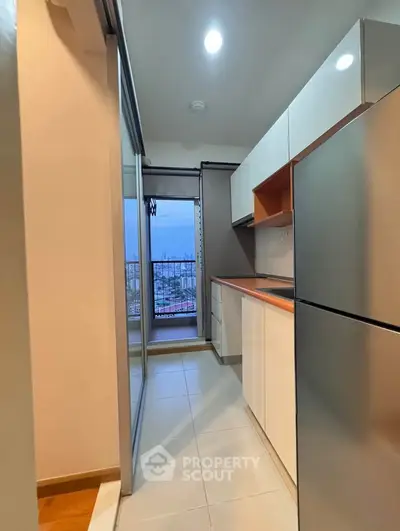 Modern kitchen with sleek cabinets and city view from balcony