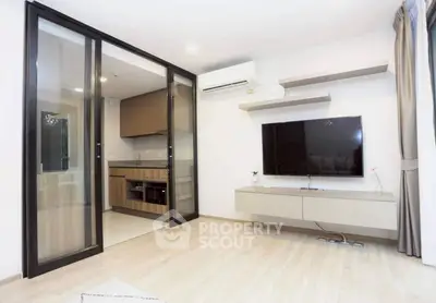 Modern living room with sleek TV setup and adjacent kitchen area