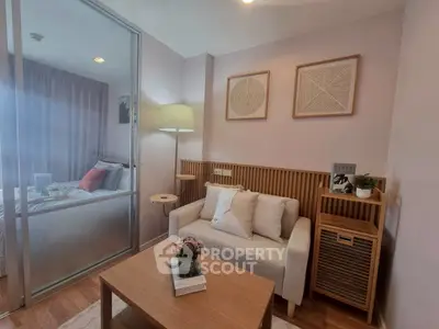 Modern living room with cozy seating and stylish decor adjacent to a bedroom.