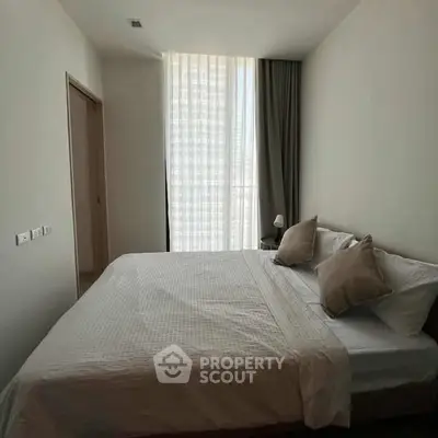 Cozy bedroom with natural light and minimalist decor, perfect for relaxation.