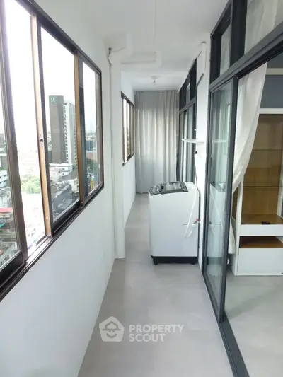 Modern balcony with city view and washing machine in high-rise apartment