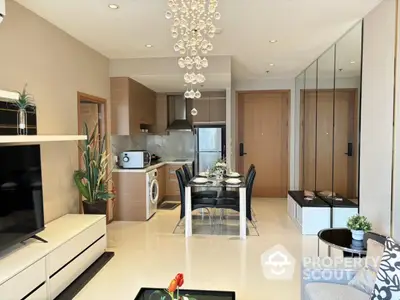 Modern open-plan living room with stylish kitchen and dining area, featuring elegant decor and natural light.