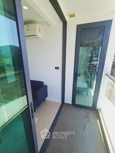 Modern balcony with glass doors and scenic view in a contemporary apartment.