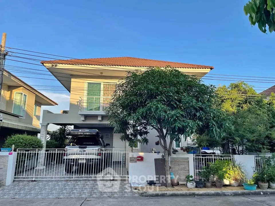 Charming two-story house with spacious driveway and lush greenery in a serene neighborhood.