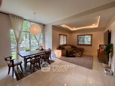 Spacious living room with elegant dining area and large windows