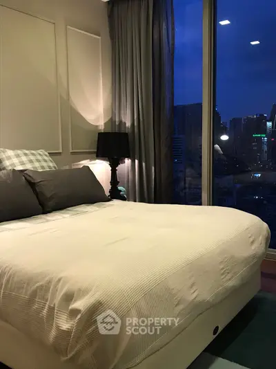 Luxurious bedroom with city view, featuring elegant decor and ambient lighting.