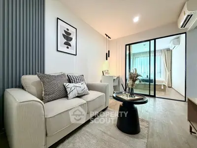 Modern living room with stylish decor and open view to bedroom