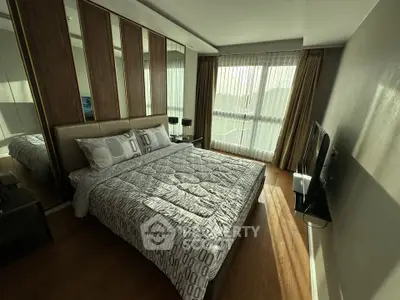 Modern bedroom with stylish decor and large windows offering natural light.