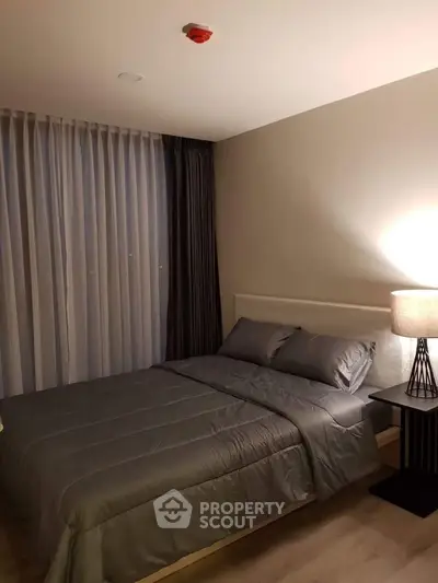 Cozy bedroom with modern decor and soft lighting, featuring a comfortable bed and elegant curtains.
