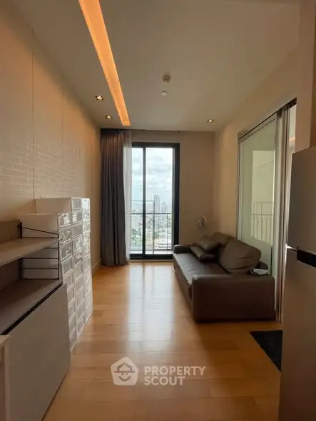 Modern living room with city view, featuring sleek furniture and floor-to-ceiling windows.