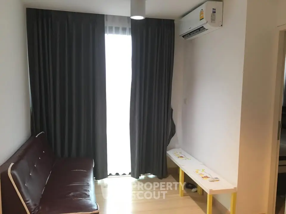Cozy living room with modern sofa and air conditioning, perfect for relaxation.