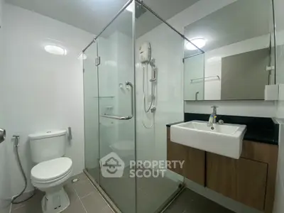 Modern bathroom with glass shower enclosure and sleek fixtures