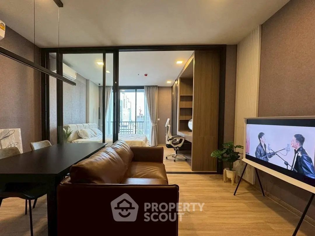 Modern living room with open layout, stylish furniture, and city view balcony.