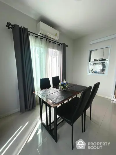 Modern dining area with sleek table and chairs, large window, and air conditioning unit.