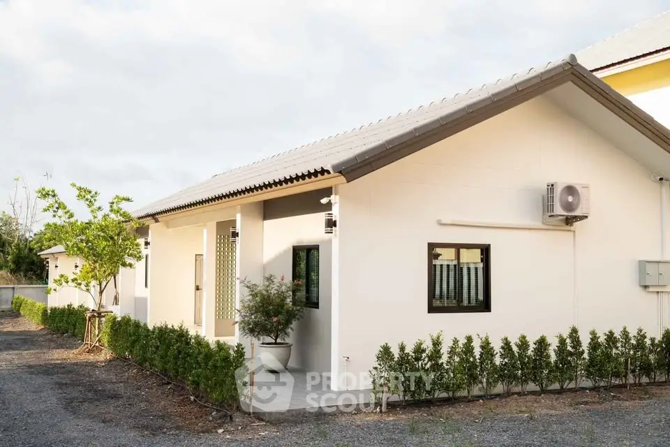 Charming single-story house with modern exterior and lush greenery