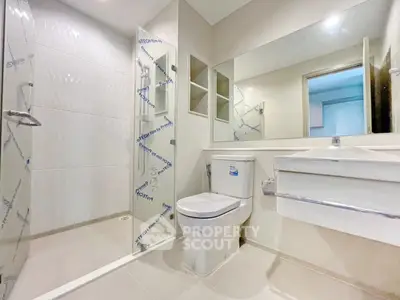 Modern bathroom with glass shower and sleek fixtures in a contemporary home.