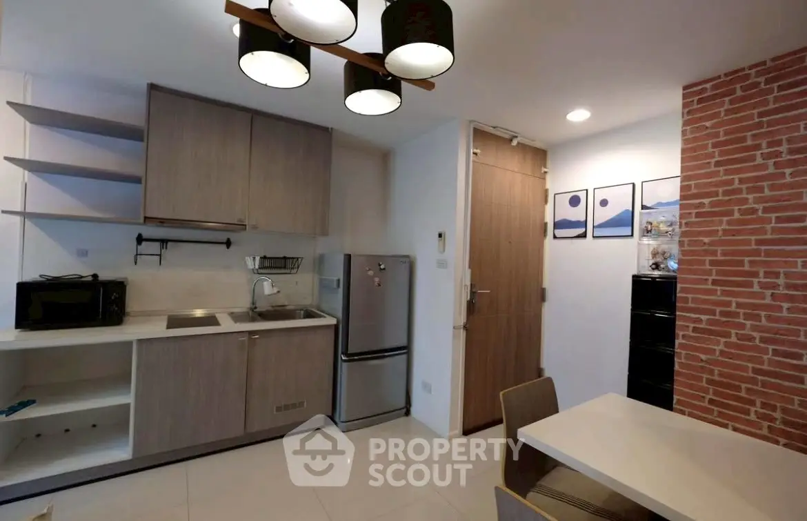 Modern kitchen with sleek cabinetry and stainless steel appliances in a stylish apartment.