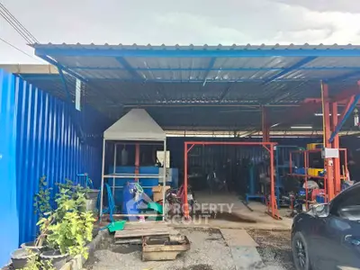 Industrial property with metal roofing and open workspace, ideal for manufacturing or storage.