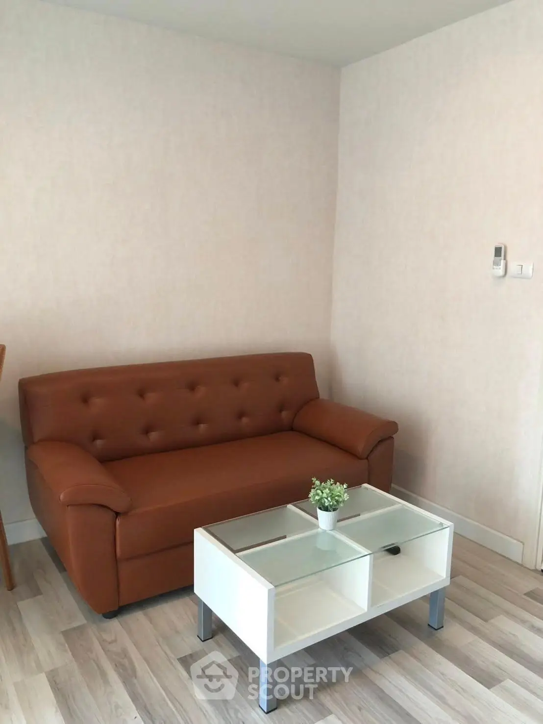 Cozy living room with brown sofa and modern glass coffee table