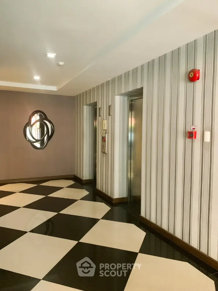 Modern building elevator lobby with stylish decor and checkered flooring