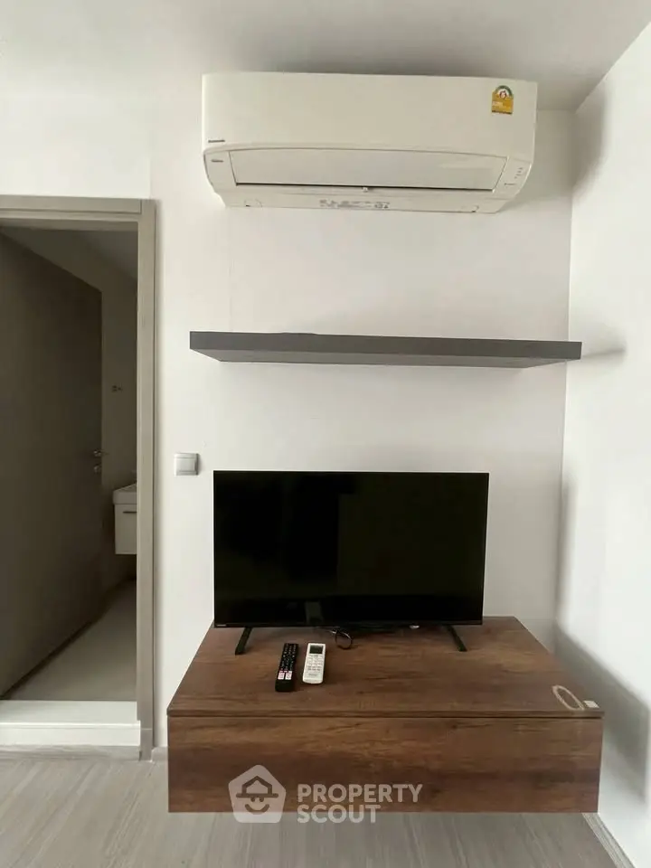 Modern living room with air conditioning and sleek TV setup, perfect for comfortable living.