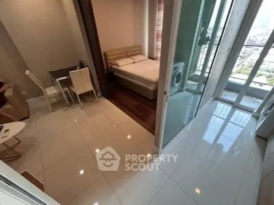 Modern apartment with open layout, featuring a cozy bedroom, dining area, and balcony with city view.