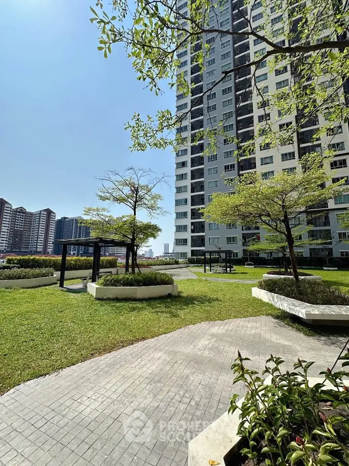 Modern high-rise building with lush green garden and paved walkways, perfect for urban living.