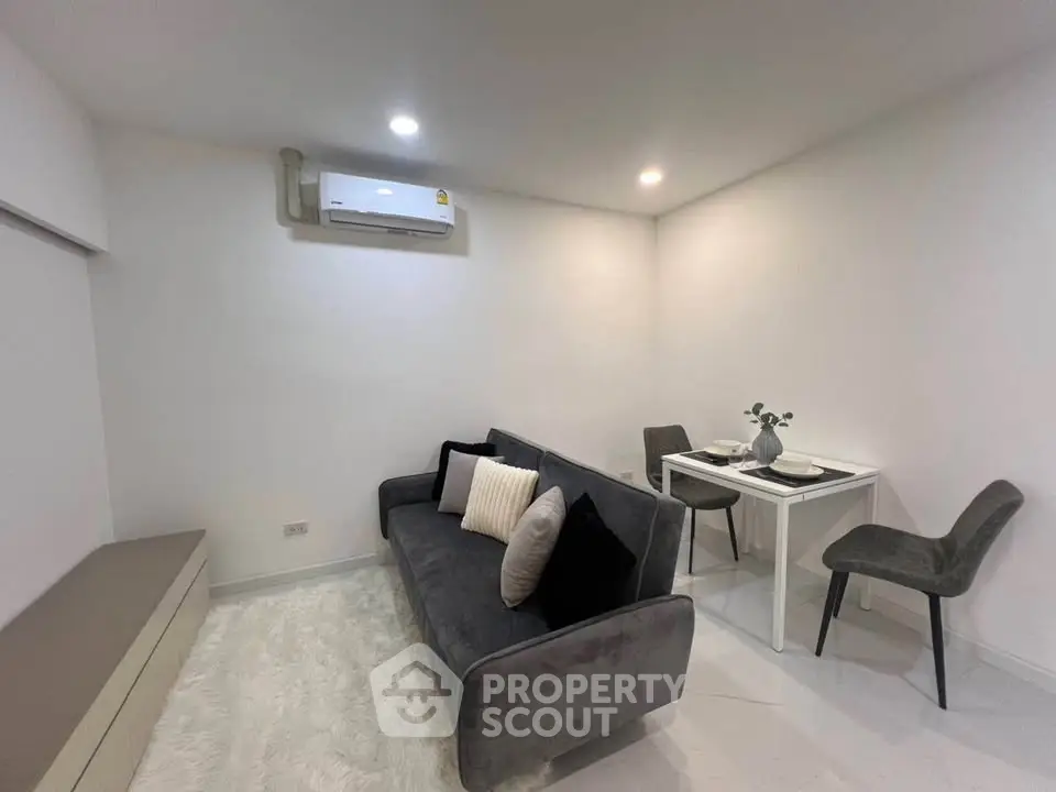 Modern living room with sleek gray sofa and dining area