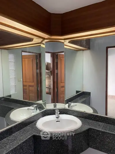Elegant bathroom with modern corner sink and mirrored walls