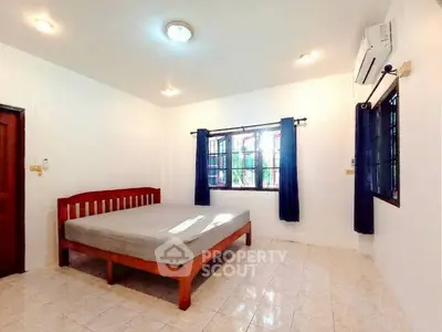 Spacious bedroom with large window and air conditioning in a minimalist style.