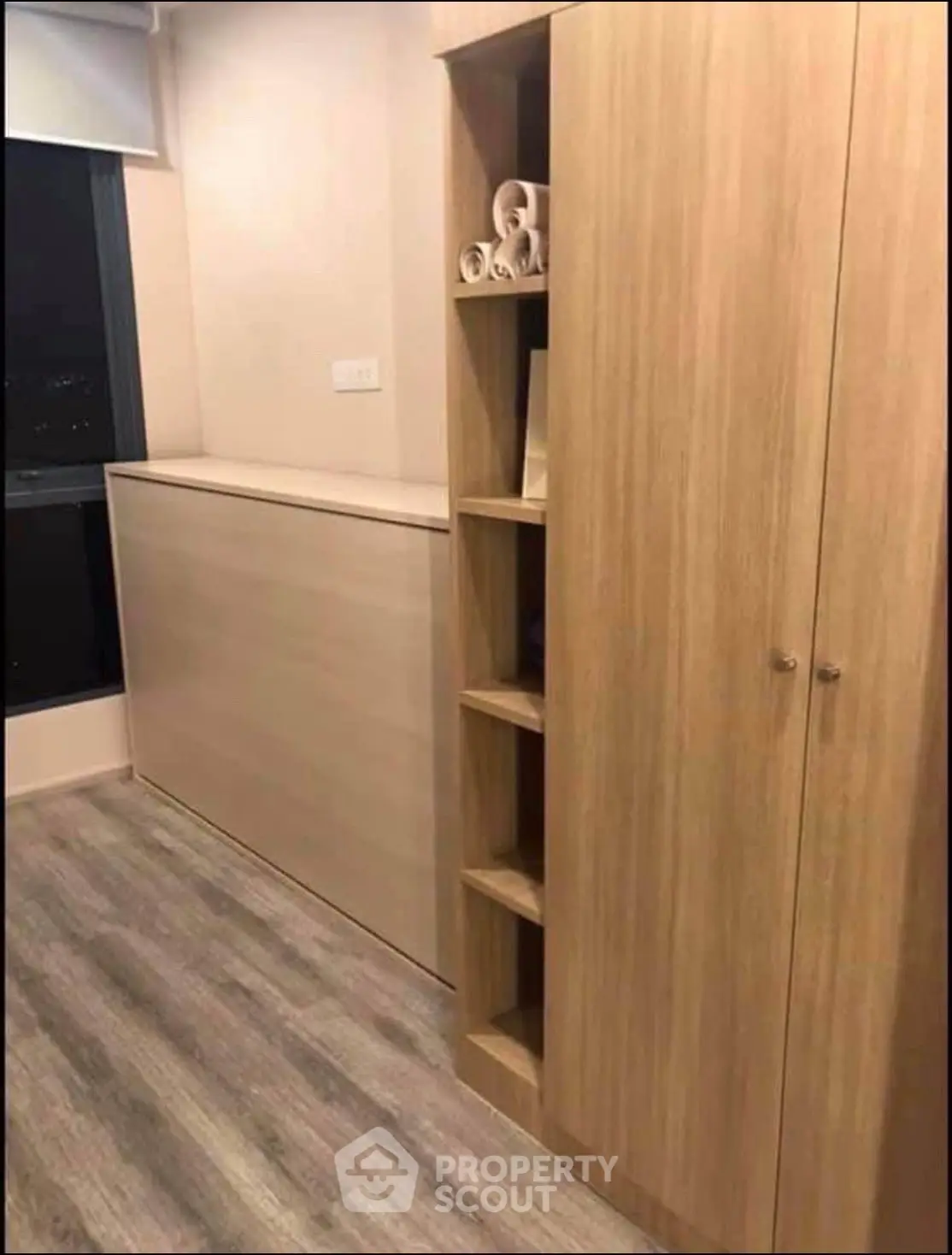 Modern storage space with sleek wooden cabinets and shelves in a cozy room.