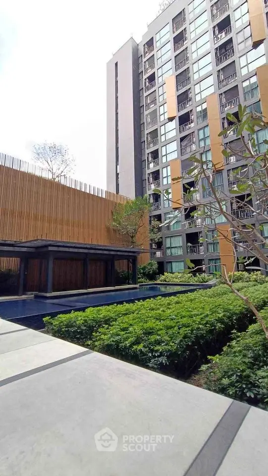 Modern apartment building with lush garden and pool view