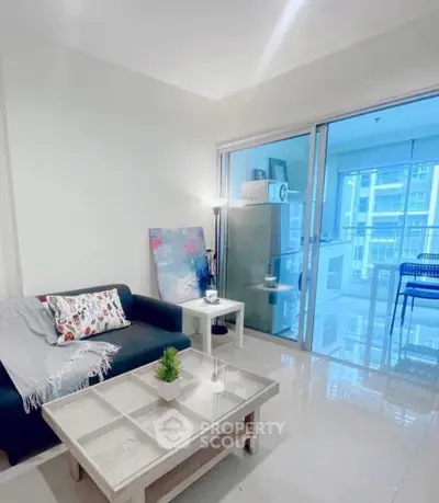 Modern living room with sleek furniture and glass balcony doors in a high-rise apartment.