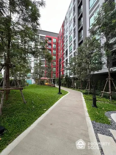 Modern apartment building with lush garden pathway and vibrant facade