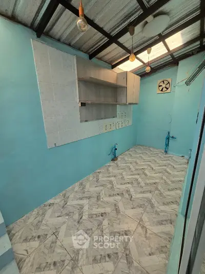 Spacious kitchen area with tiled flooring and open layout, ready for customization.