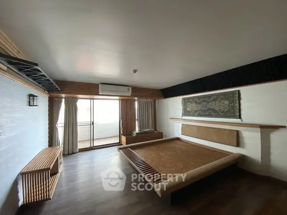 Spacious bedroom with wooden accents and balcony access