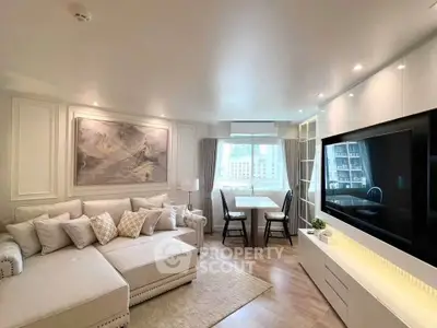 Elegant living room with modern decor, large TV, and cozy seating area, perfect for relaxation and entertainment.