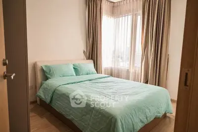 Cozy bedroom with natural light and elegant curtains, perfect for relaxation.