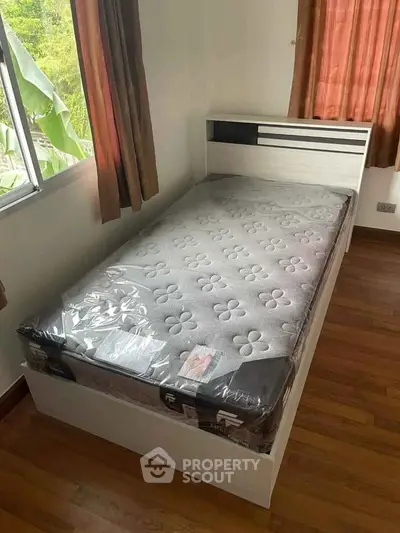 Cozy bedroom with single bed and natural light from window