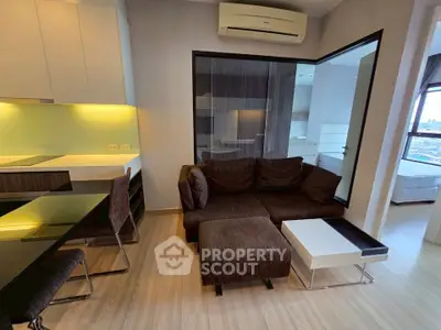 Modern living room with brown sofa, glass table, and air conditioning in a stylish apartment.
