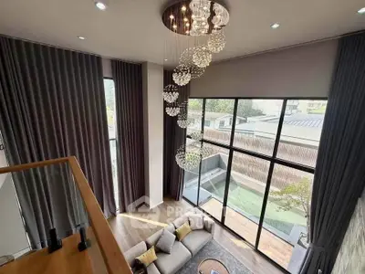 Luxurious living room with high ceilings and elegant chandelier in modern home