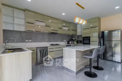 Modern kitchen with sleek cabinetry, island seating, and stainless steel appliances.