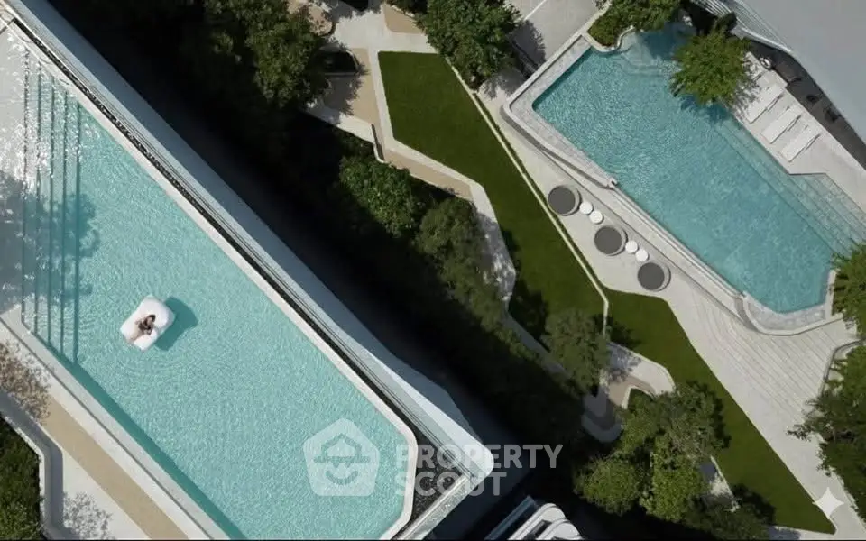Luxurious aerial view of modern rooftop pools with lush greenery