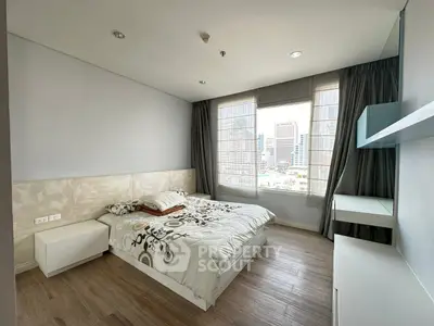 Modern bedroom with city view, featuring stylish decor and ample natural light.